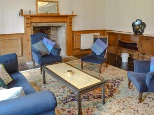 a living room with chairs and a table and a piano at Manor House in Uny Lelant +13 photos