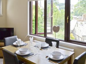 a dining room table with chairs and a large window at Watersmeet in Looe