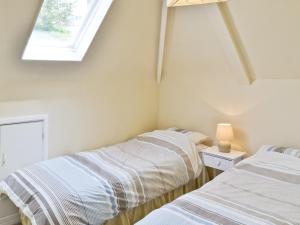 two beds in a room with a window at Watersmeet in Looe +6 photos