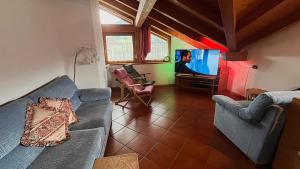 un salon avec un canapé et une télévision dans l'établissement Lauton Dolomiti Relax Apartment - mit Jacuzzi-Badewanne, à Ziano di Fiemme
