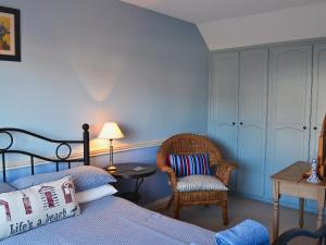 une chambre avec un lit, une chaise et une table dans l'établissement Harbour Cottage, à Winterton-on-Sea