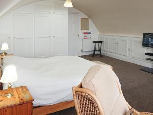 a bedroom with a bed and a chair and a table at Seascape in Ramsgate