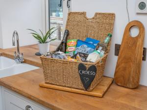 a basket of food and drinks on a kitchen counter at Cwtch Ty Gwyn in Llandeilo