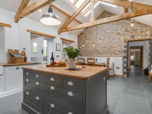 an open kitchen with a stone wall and a large island at Cwtch Ty Gwyn in Llandeilo +12 photos