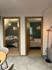 a room with two beds and a table and a mirror at Charmant appartement avec vue sur les vignes in Ammerschwihr