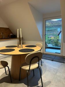 a dining room table with chairs and a large window at Charmant appartement avec vue sur les vignes in Ammerschwihr