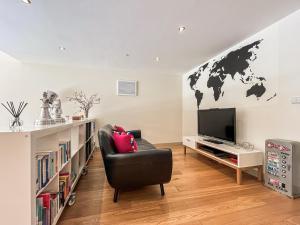a living room with a black chair and a world map on the wall at Springfields in North Wootton