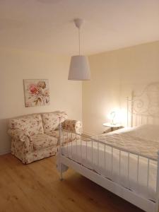 a bedroom with a bed and a couch at Casa Lobi - Die Ferienwohnung mit Ausblick! in Korbach