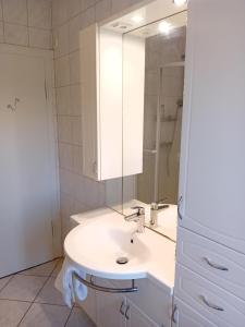 a white bathroom with a sink and a mirror at Casa Lobi - Die Ferienwohnung mit Ausblick! in Korbach +8 photos