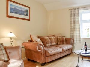 ein Wohnzimmer mit einer Couch und einem Sessel in der Unterkunft Jessamine Cottage in Blairgowrie