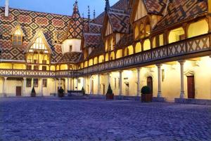 a large building with a tile roof with a courtyard at Le petit Appartement in Beaune