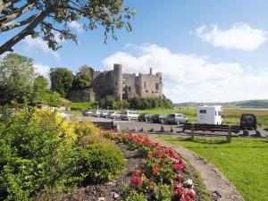 ein Schloss mit Autos auf einem Parkplatz in der Unterkunft Coast View Cottage - Hw7745 in Pendine