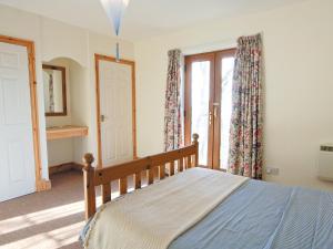 ein Schlafzimmer mit einem Bett und einem großen Fenster in der Unterkunft Coast View Cottage - Hw7745 in Pendine