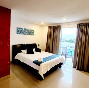 a bedroom with a large bed and a large window at CHIPICHAPE INN in Cali +25 photos