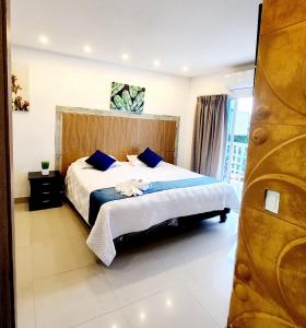 a bedroom with a large bed with blue pillows at CHIPICHAPE INN in Cali