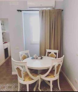 een witte tafel en stoelen in een kamer bij Casa di Fló in Bari