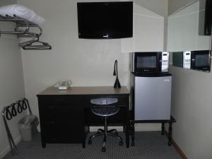 a room with a desk with a microwave and a computer at The Triangle Motel in Alma