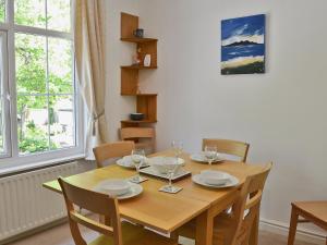 a dining room table with chairs and a wooden table and a window at Hope Cottage in Lindale