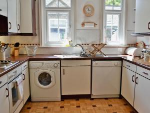 a kitchen with a washing machine and a dishwasher at Hope Cottage in Lindale