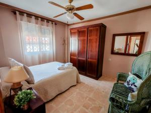 a bedroom with a bed and a ceiling fan at A un metro Sevilla in San Juan de Aznalfarache +37 photos