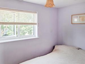 a bedroom with a bed and a window at Brightlands Apartment in Poughill