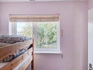 a bedroom with a window with a bed and a window sill at Brightlands Apartment in Poughill