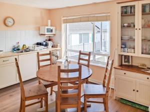 a kitchen with a table and chairs and a window at Brightlands Apartment in Poughill