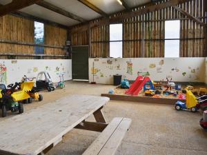 a room with a wooden table and toys in it at The Stable - Ijx in Brigham