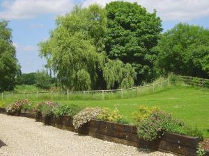 a row of flowers in a garden with a fence at The Stable - Ijx in Brigham