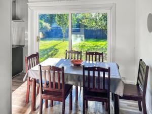 Una mesa de comedor con sillas y una gran ventana. en Pillango, en Cowes