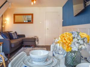 a living room with a table with a vase of flowers at Seashell House in Burnham on Sea