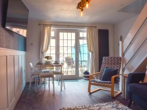 a living room with a table and chairs and a window at Seashell House in Burnham on Sea