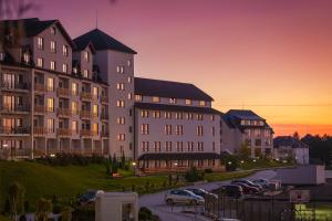 コパオニクにあるApartman The Nestの駐車場に車が駐車されている大きな建物