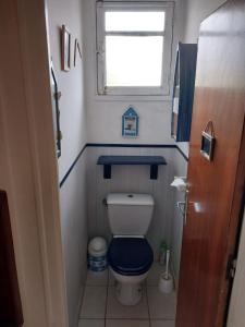a small bathroom with a toilet with a blue lid at Chambre privée, communs partagés avec autres Locataires in Tregueux