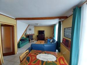 a living room with a table and a blue couch at Chambre privée, communs partagés avec autres Locataires in Tregueux