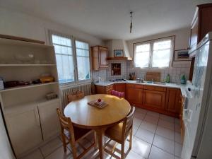 a kitchen with a wooden table and a table and chairs at Chambre privée, communs partagés avec autres Locataires in Tregueux +4 photos