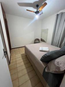 een slaapkamer met een bed en een plafondventilator bij Apartamento 3 suítes perto da Praia do forte e Passagem in Cabo Frio
