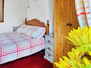 a small bedroom with a bed and a dresser at Ginny's Cottage in Haworth +8 photos
