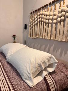 a bedroom with a bed with a white pillow and a wall with a basket at Nanabi in Brisas de Zicatela