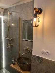 a bathroom with a sink and a glass shower at Cassovia Hostel in Košice