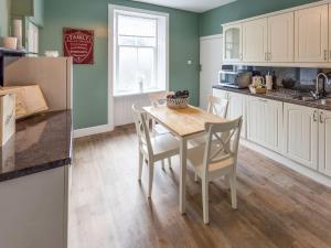 a kitchen with a table and chairs in a kitchen at Littlebay Apartment in Oban