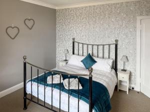a bedroom with a bed with blue and white sheets at Littlebay Apartment in Oban