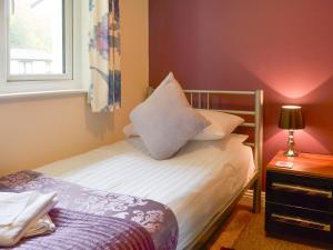 a small bedroom with a bed and a window at Talland Bay in Saint Cleer +6 photos