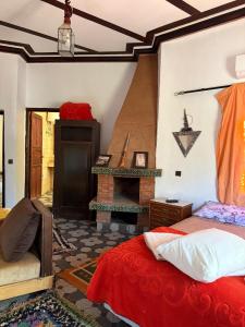a bedroom with a fireplace and a bed and a table at Riad Malak in Ouirgane