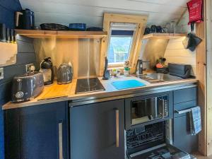 a small kitchen with a sink and a microwave at Totaig - Uk50717 in Kirkton