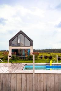 a house with a swimming pool and a wooden fence at Rybical 42 in Rybical