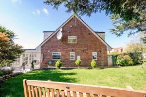 una casa de ladrillo con un banco en el patio en 3 Bed House With Free Parking, Garden & Fast Wifi, en Cardiff