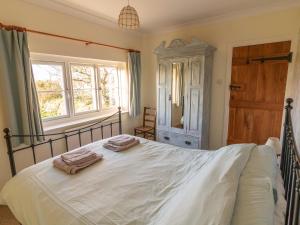 MathryにあるLittle Roostのベッドとタオル2枚のある寝室