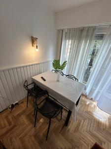 ein weißer Tisch und Stühle in einem Raum mit einem Fenster in der Unterkunft Depto 2 ambientes Zona Aldrey in Mar del Plata
