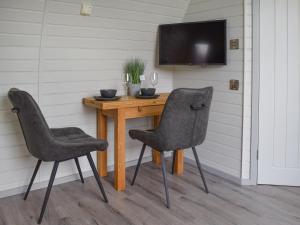 mesa con 2 sillas y TV en la pared en Laurel Pod - Uk47203, en Westhead